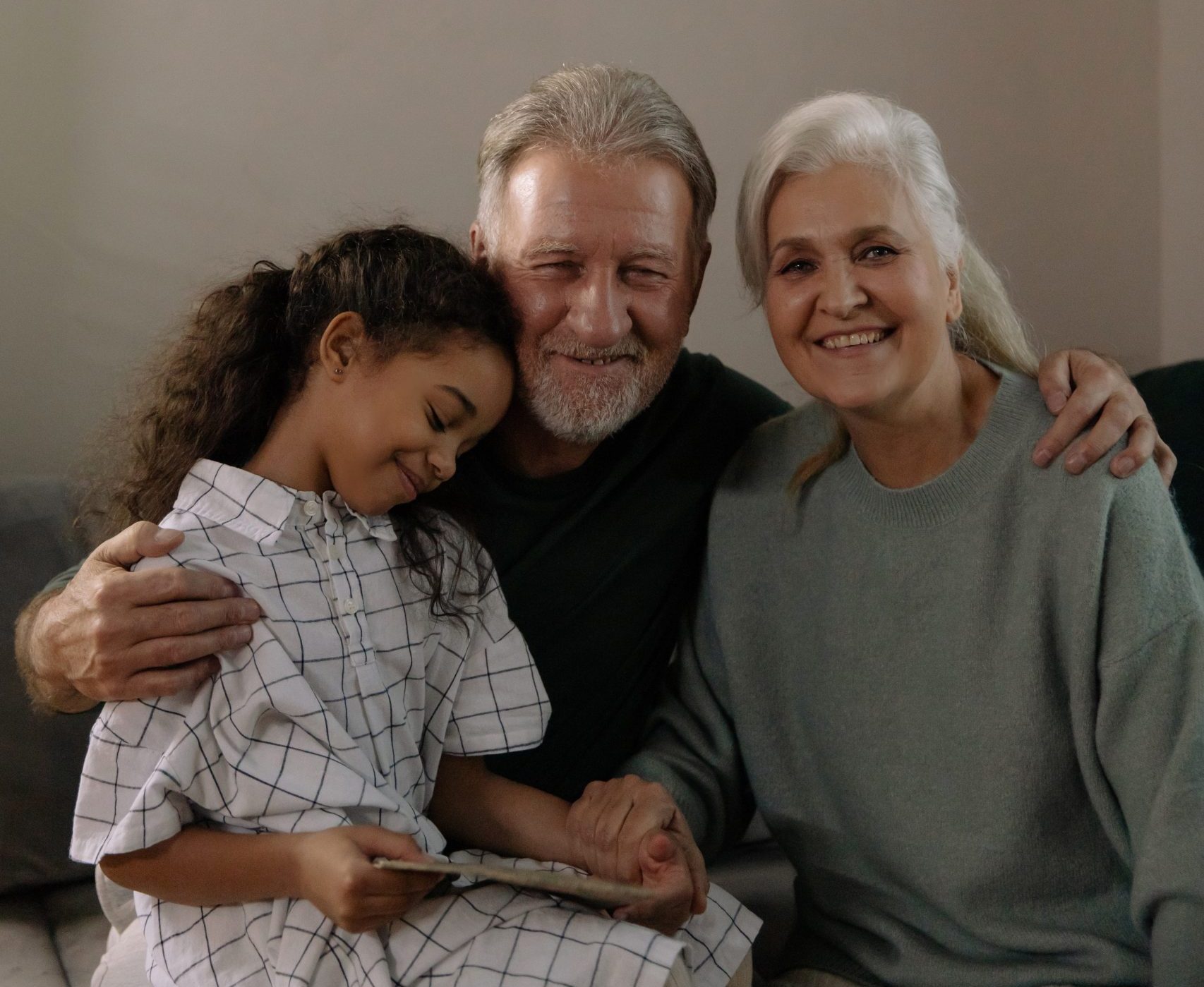 A smiling couple with their grand daughter